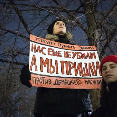 At a Moscow rally in support of domestic violence legislation, a woman holds a banner that reads "We demand a law against domestic violence. We are not killed yet, but we're close", Monday, Nov. 25, 2019.