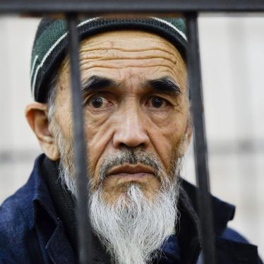 Ethnic Uzbek journalist Azimzhan Askarov, who was arbitrarily arrested, tortured, convicted after an unfair trial and jailed for life looks through metal bars during hearings at the Bishkek regional court, Kyrgyzstan.