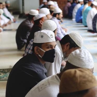 Muslims wear protective masks while offering Friday prayers