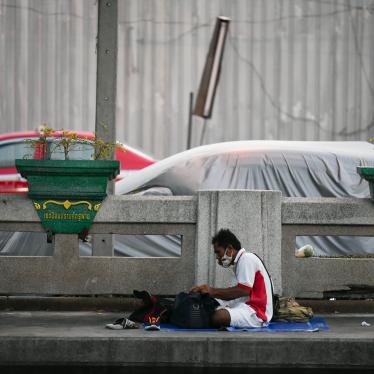 A homeless man sits beside the road outside the Hua Lamphong train station in Bangkok, Thailand, April 9, 2020.