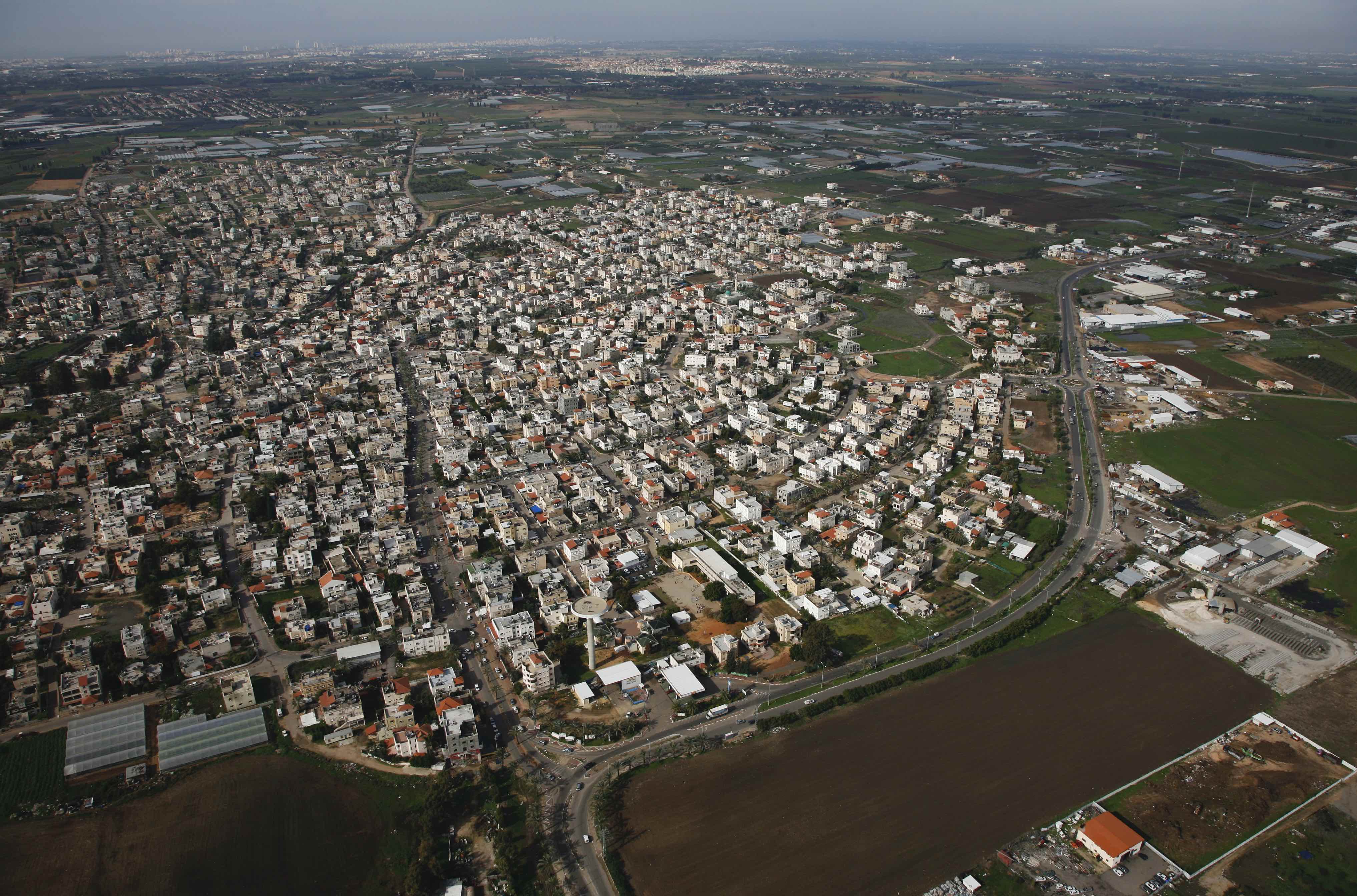 The dense residential core of Qalansawa, a Palestinian town in central Israel, with its lands zoned for agricultural use in the background. Aerial photography taken between 2011 and 2015.