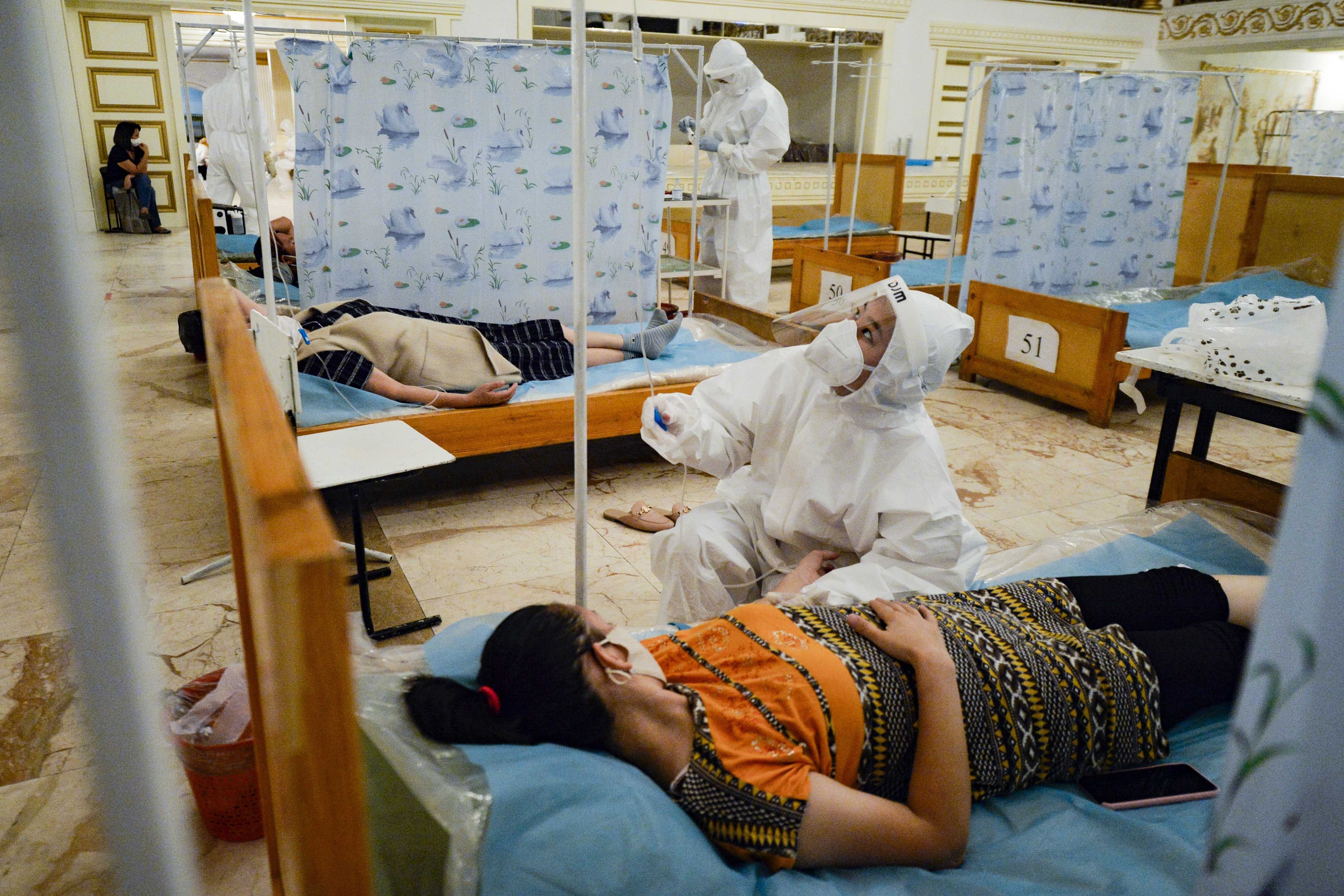 Cette travailleuse de la santé examinait la tubulure de perfusion intraveineuse administrée à une patiente dans un restaurant converti en clinique temporaire, lors de la pandémie de Covid-19 à Bichkek, au Kirghizistan, en juillet 2020.