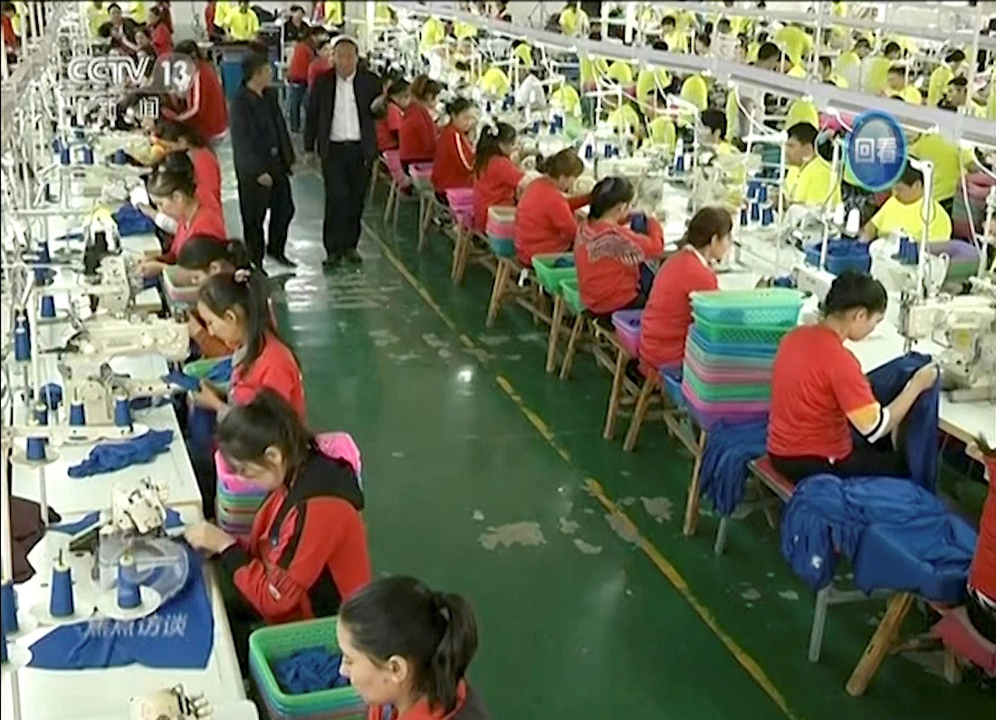 In this file image from undated video footage run by China's CCTV via AP Video, Muslim trainees work in a garment factory at the Hotan Vocational Education and Training Center in Hotan, Xinjiang, northwest China.