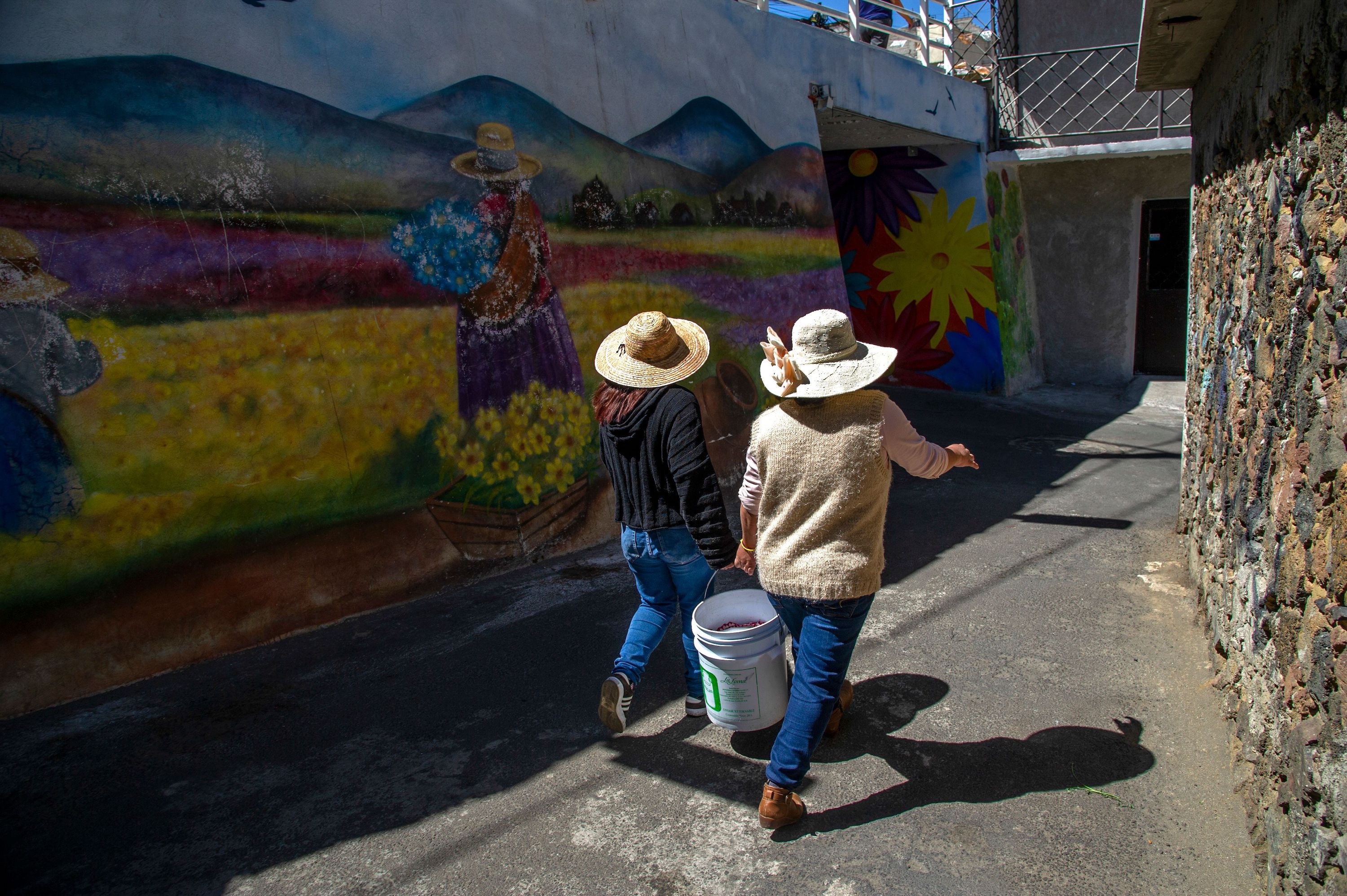 Members of the collective Mujeres de la Tierra, walk with corn to a neighborhood mill, in Milpa Alta, Mexico City, on February 16, 2021. The collective Mujeres de la Tierra started in May, 2020, as a way to help survivors of domestic violence generate an income amid the COVID-19 pandemic.