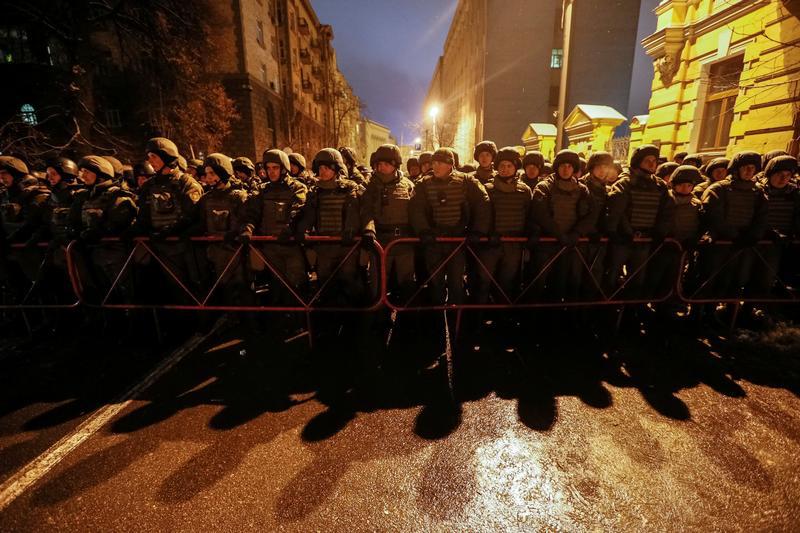 Сотрудники Национальной гвардии стоят на посту у здания президентской администрации в то время, как активисты националистических групп проводят анти-правительственную демонстрацию, требуя освобождения своих сторонников из тюрьмы в Киеве, Украина, 1 декабр