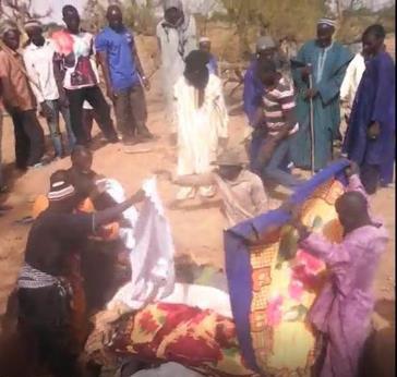 Des villageois peuls enterrent plusieurs personnes dans une fosse commune après leur assassinat dans le village de Koumaga, près de Djenné dans le centre du Mali le 23 juin 2018, lors d'une attaque qui aurait été perpétrée par une milice dozo.
