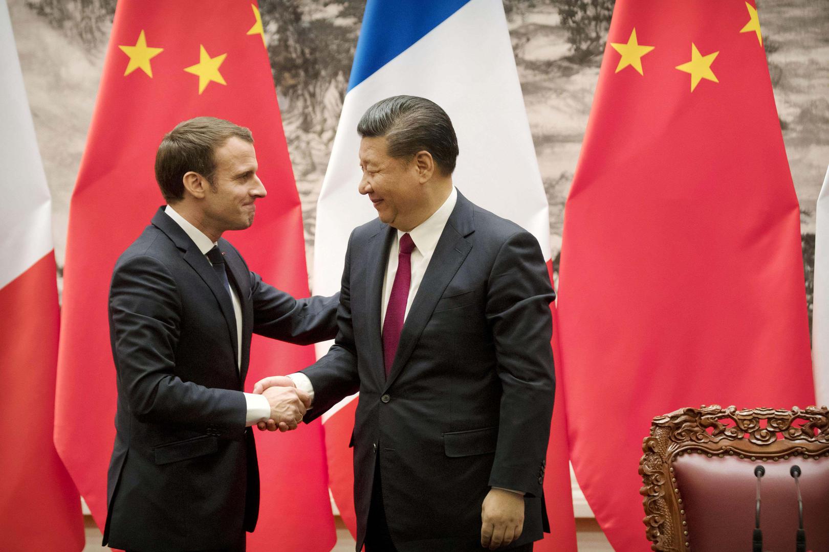 Le président français Emmanuel Macron et le président chinois Xi Jinping se serrent la main après leur conférence de presse conjointe au Palais du Peuple à Pékin, le 9 janvier 2018.  © 2018 Kyodo via AP Images