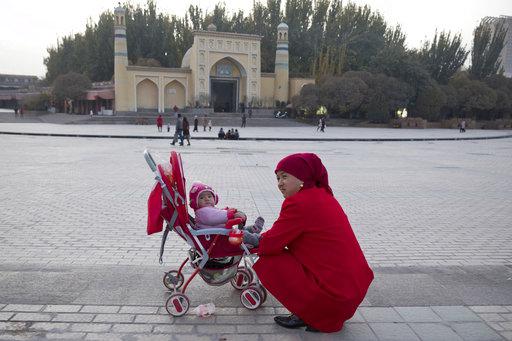 一对维族母子在新疆喀什艾提尕清真寺前，2017年11月4日。