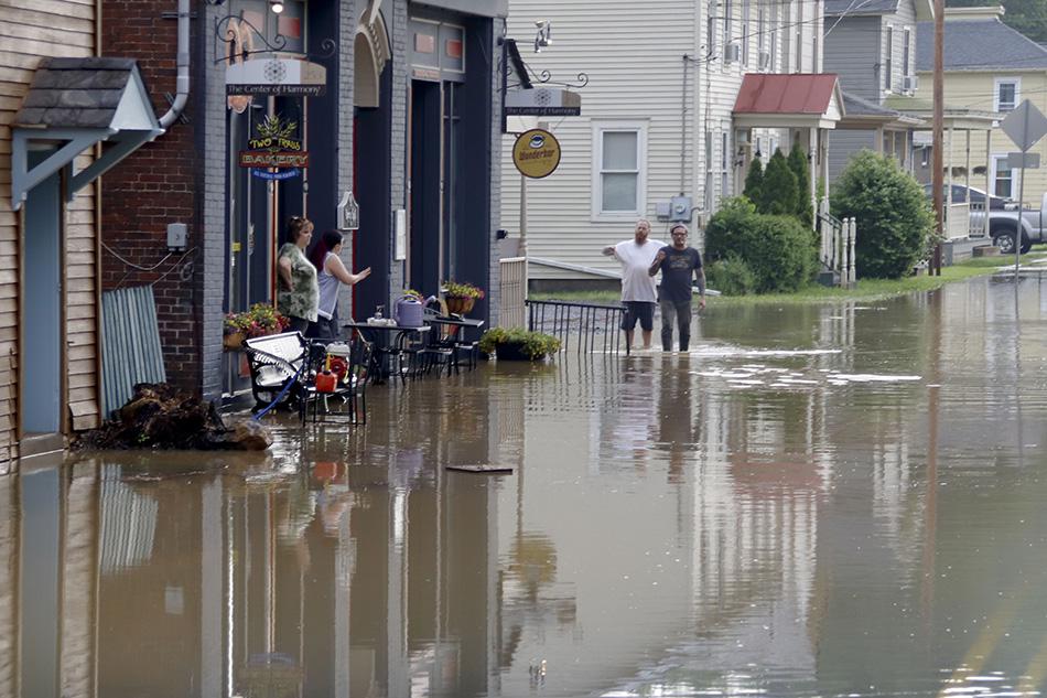 Business owners and workers assess flood waters in Harmony, Pennsylvania. 