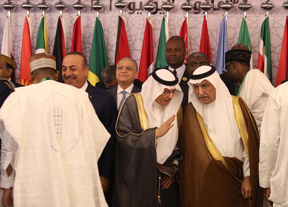 伊斯兰合作组织秘书长优素福·阿卜杜拉·乌赛明（中）和沙特阿拉伯外长易卜拉辛·阿萨夫（右）出席伊斯兰及阿拉伯国家外长会议，在团体合照前交谈，吉达，2019年5月30日。