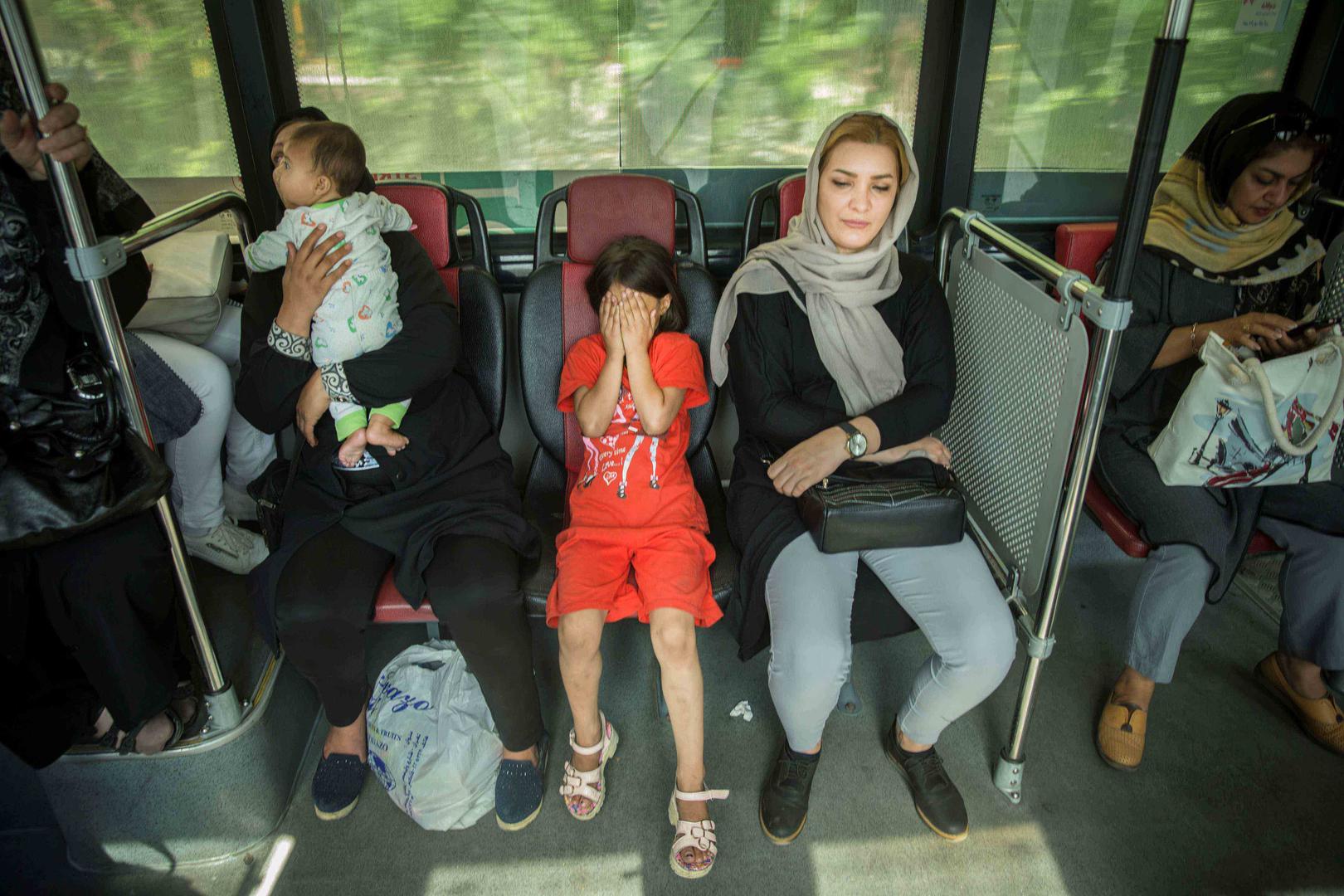 Girl and women ride on a bus in Tehran © Reuters