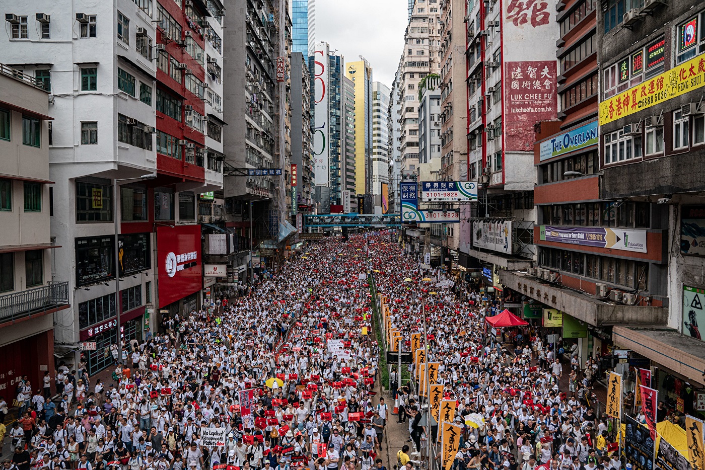 محتجون يسيرون في شارع خلال مظاهرة احتجاجية ضد مشروع قانون تسليم المطلوبين في 9 يونيو/حزيران 2019 في هونغ كونغ.