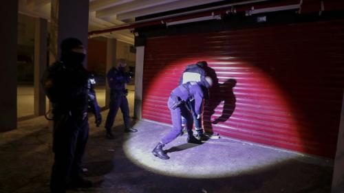 Police search a man at night