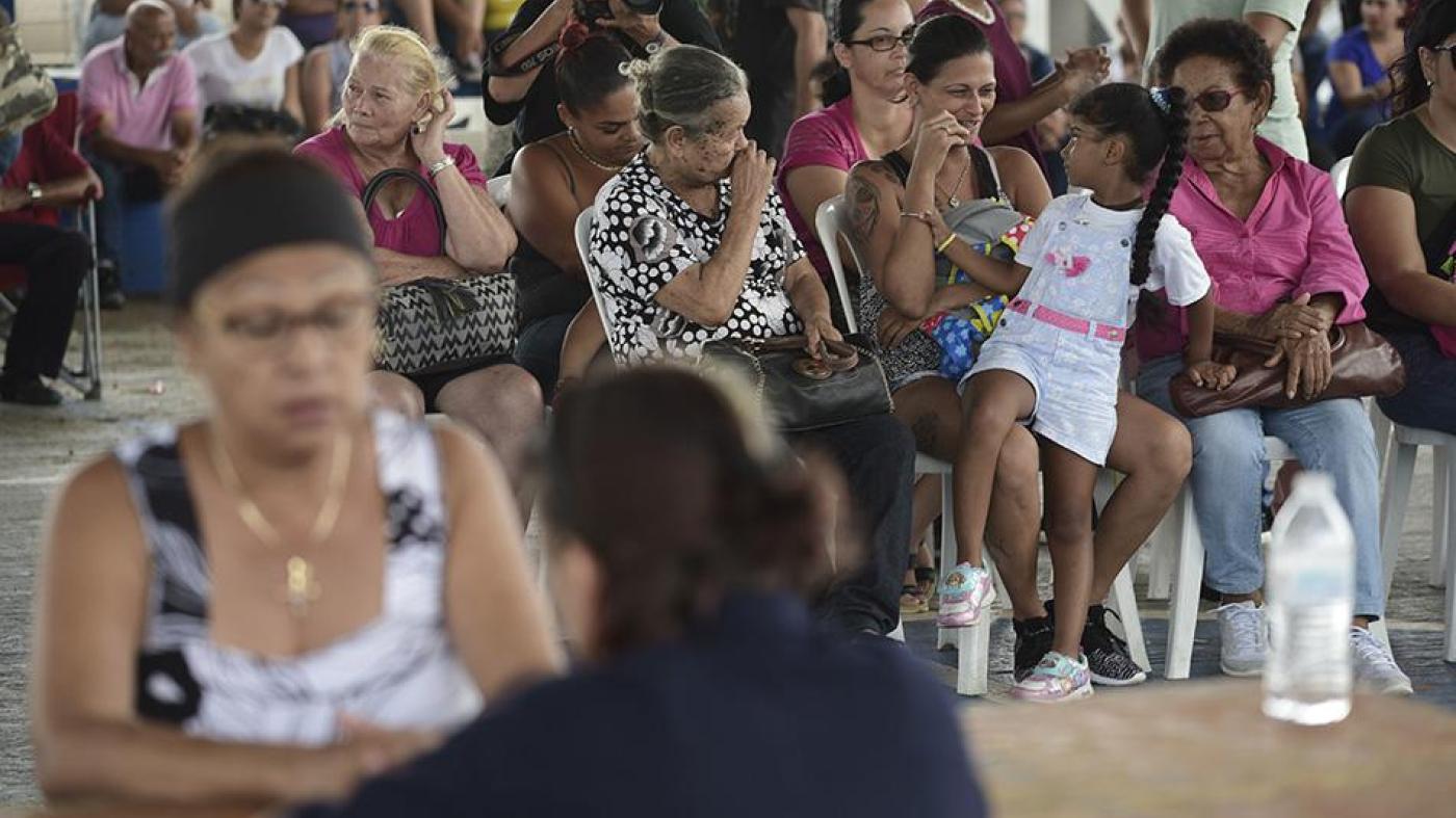 People wait at the Jose de Diego Elementary School to file FEMA forms for federal aid in the aftermath of Hurricane Maria in Las Piedras, Puerto Rico