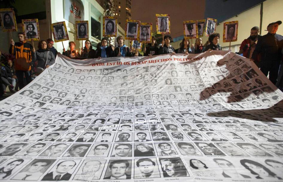 Demonstrators show photos of people killed during Brazil's dictatorship outside a police station that used to be a torture center used by the dictatorship in Sao Paulo, Brazil on August 5th, 2019.