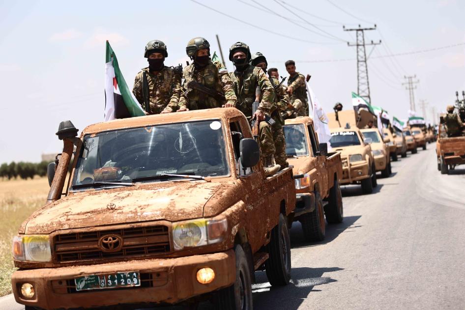 Türkiye destekli Suriye Milli Ordusu mensupları, Suriye Demokratik Güçleri tarafından kontrol edilen bölgelere yönelik askeri eylem hazırlıklarının bir parçası olarak 9 Haziran 2022`de Halep Valiliği kırsalında bir askeri geçit törenine katılıyor.