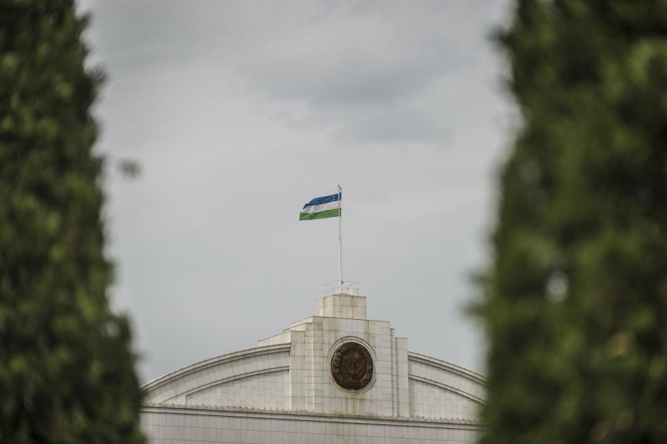 The Uzbekistan flag flies at the top of a government building