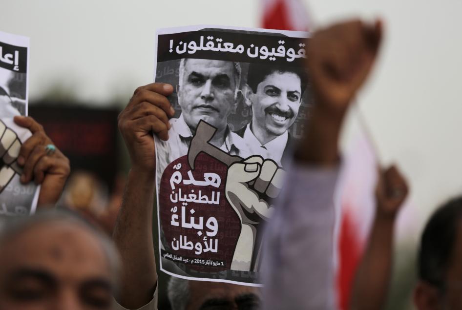 Seorang pengunjuk rasa anti-pemerintah Bahrain memegang poster yang menyerukan pembebasan aktivis hak asasi manusia yang dipenjara, Nabeel Rajab (yang dibebaskan pada tahun 2020), kiri, dan Abdulhadi al-Khawaja, kanan, di Manama, Bahrain, 1 Mei 2015.