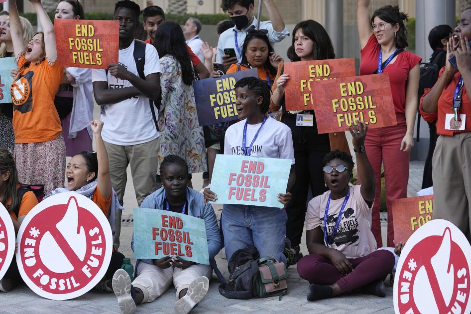 Plusieurs activistes dont l’Ougandaise Vanessa Nakate, à genoux vers le centre de la photo, tenaient des pancartes appelant à la fin de l’exploitation de combustibles fossiles lors de la conférence COP28 de l’ONU sur le climat à Dubaï, aux Émirats arabes unis, le 5 décembre 2023.
