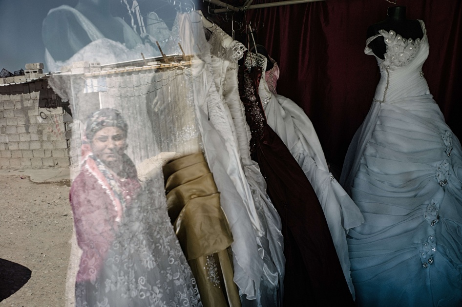 Le reflet d’une femme regardant des robes de mariée exposées dans la vitrine d’un magasin à Duhok, en Irak, le 12 octobre 2015. 