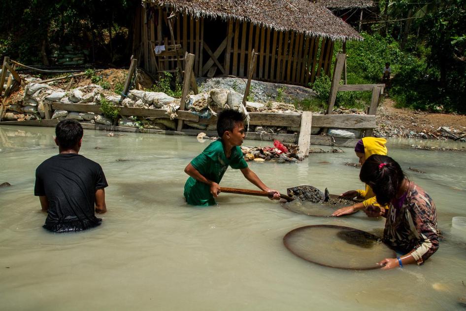 Des enfants utilisent des batées pour chercher de l'or dans la rivière Bosigon à Malaya (Camarines Norte), aux Philippines.