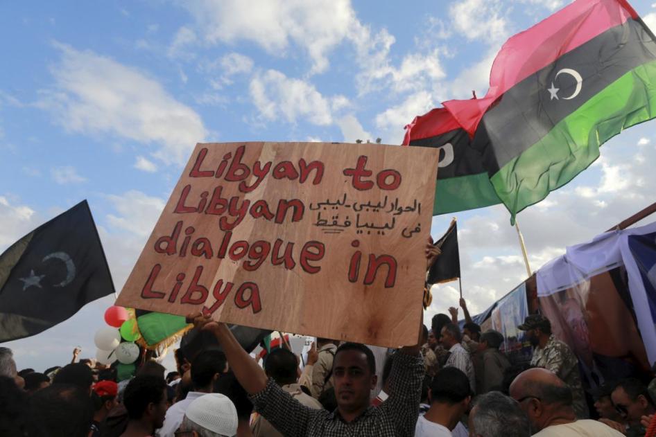 رجل يحمل لافتة خلال مظاهرة ضد مرشحي حكومة الوحدة الوطنية التي اقترحها مبعوث الأمم المتحدة إلى ليبيا برناردينو ليون في بنغازي، ليبيا، 23 أكتوبر/تشرين الأول. 