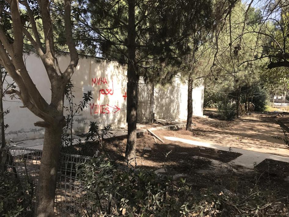 كتابة على الجدران في ساحة المستشفى الرئيسي في منبج، تحذر من وجود ألغام. 