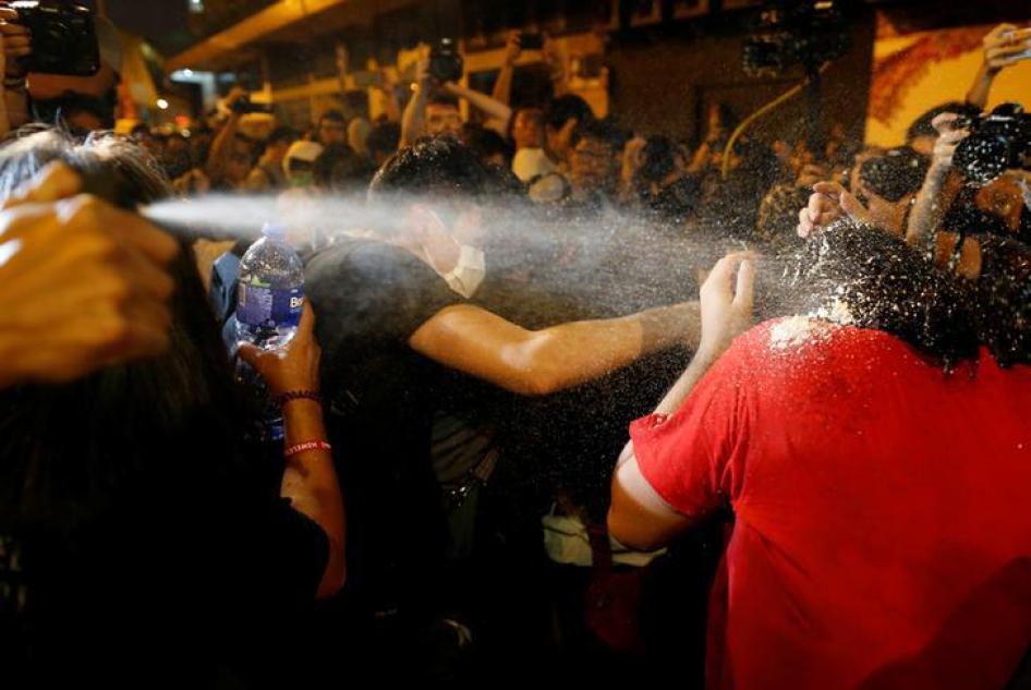 警察向抗议北京破坏法治、干涉地方政治的示威者喷洒辣椒喷雾。