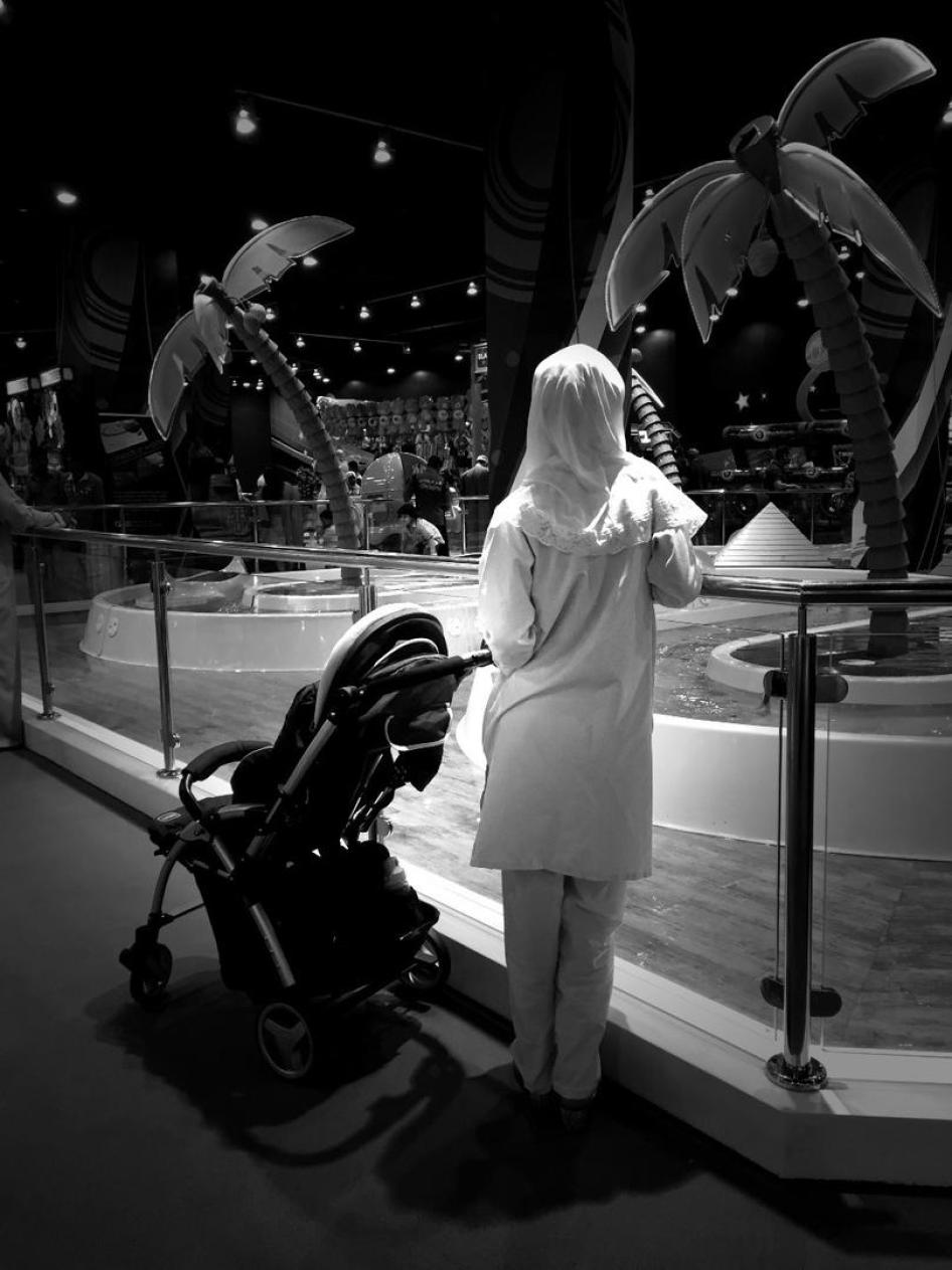 Una trabajadora doméstica cuida de un niño que juega en el centro comercial Planeta Mágico, ubicado en el centro de la ciudad de Muscat en Omán.