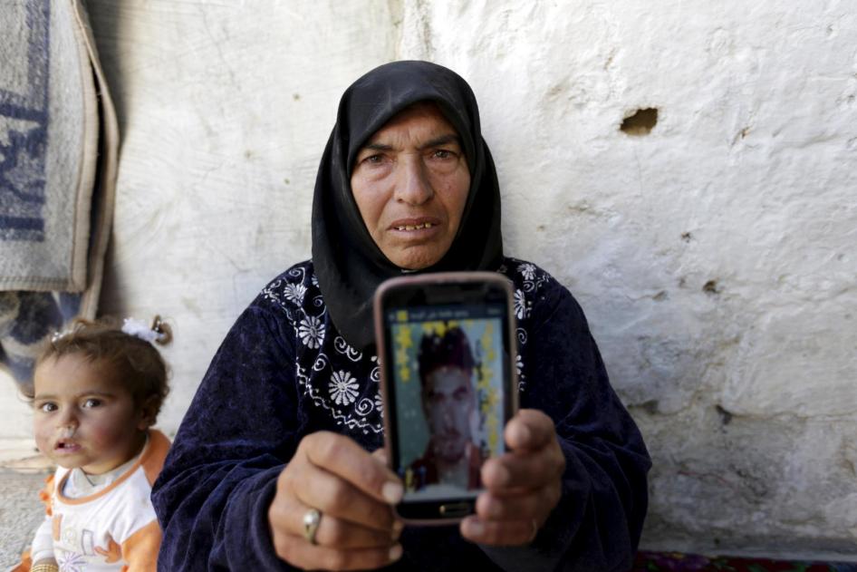 أم تعرض صورة ابنها الذي احتجزته السلطات في محافظة إدلب شمالي سوريا، 20 مارس/آذار 2016. لم تسمع أخباره منذ احتجازه. 