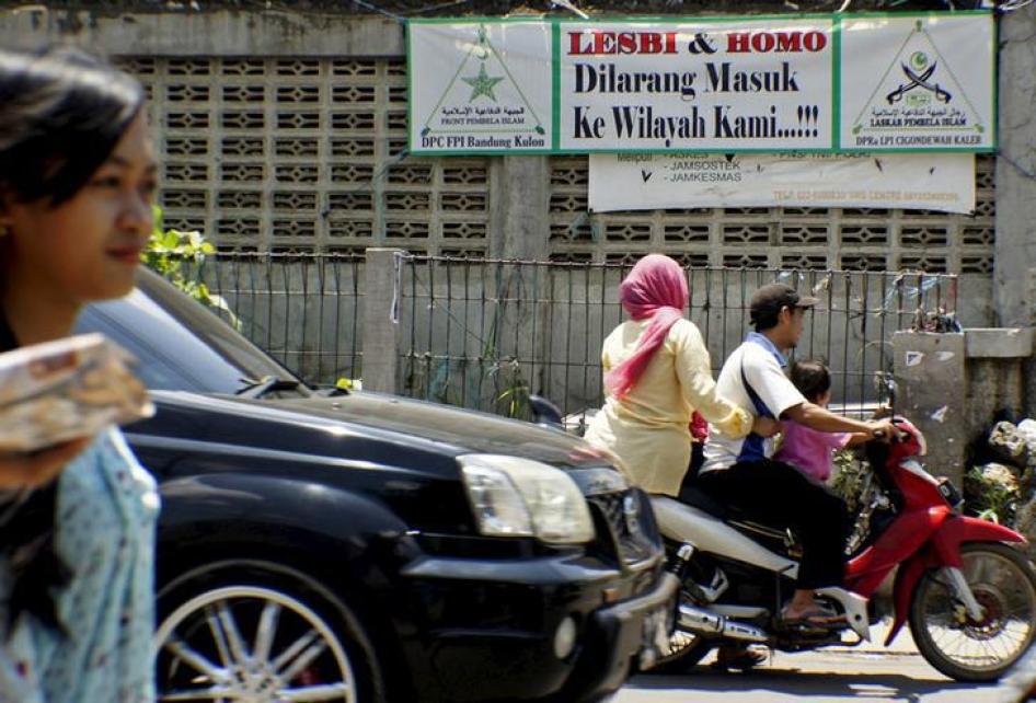 Para pengendara sepeda motor melintas di depan spanduk yang menyerukan pada warga LGBT untuk hengkang dari Cigondewah Kaler di Bandung, Jawa Barat 27 Januari 2016.