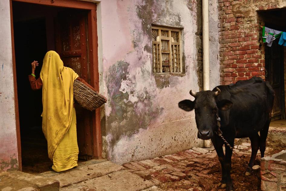 A Dalit woman enters a home in Uttar Pradesh, India, through a back entrance to remove excrement from dry toilets. 