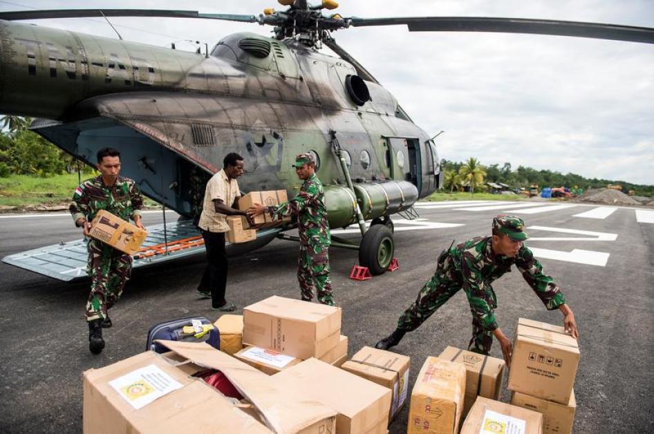Tentara Indonesia bersama seorang warga setempat membongkar muatan bantuan pangan dan medis di Ewer, Kabupaten Asmat, di kawasan terpencil Papua, Indonesia, 29 Januari 2018. 