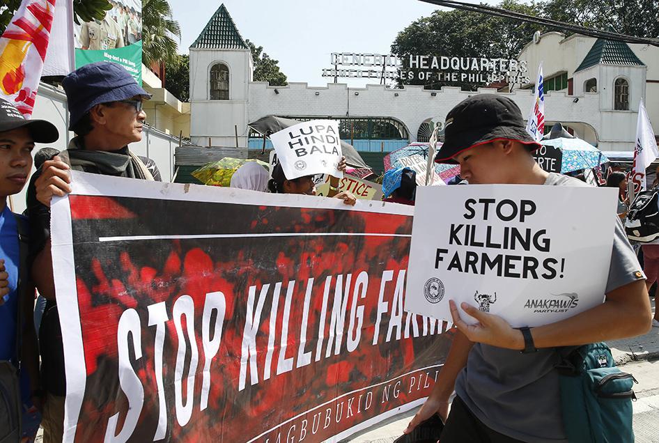 Para pengunjuk rasa membawa poster saat aksi demontrasi di luar kamp polisi dan militer pada Senin, 22 Oktober 2018 di kota Quezon di pinggiran kota dari Manila, Filipina. Mereka memprotes pembunuhan sembilan petani pada akhir pekan di kota Sagay, Negros 