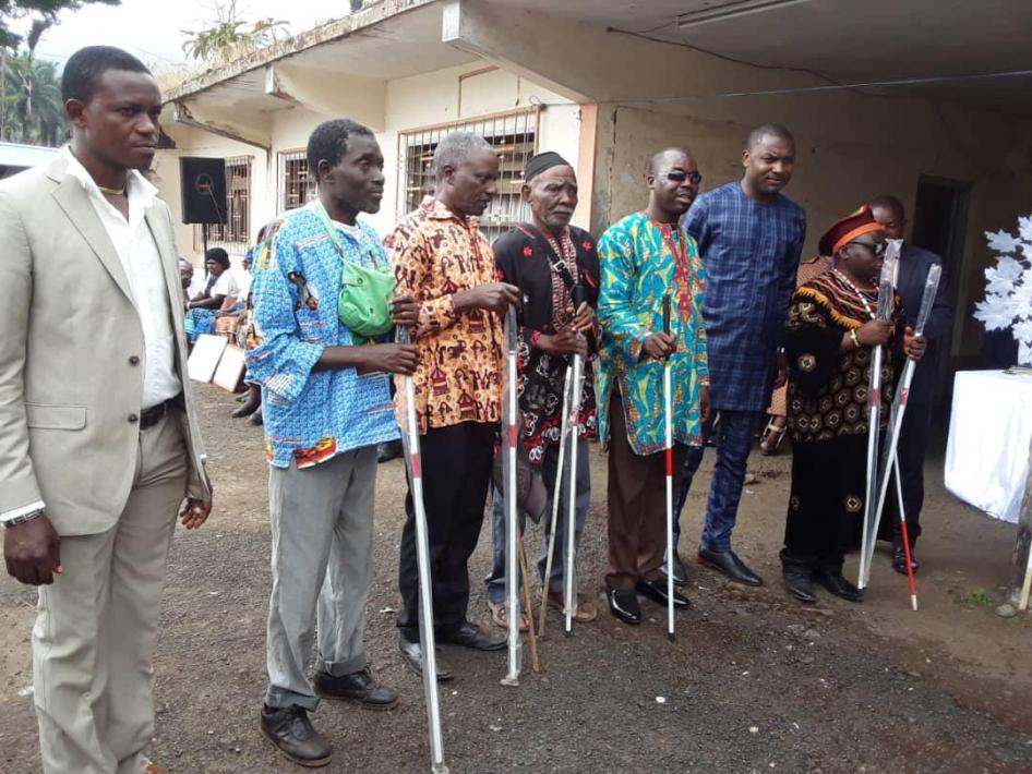 Blind people hold white canes they received from a local organization working with people with disabilities in Buea, South-West region, December 3, 2019.