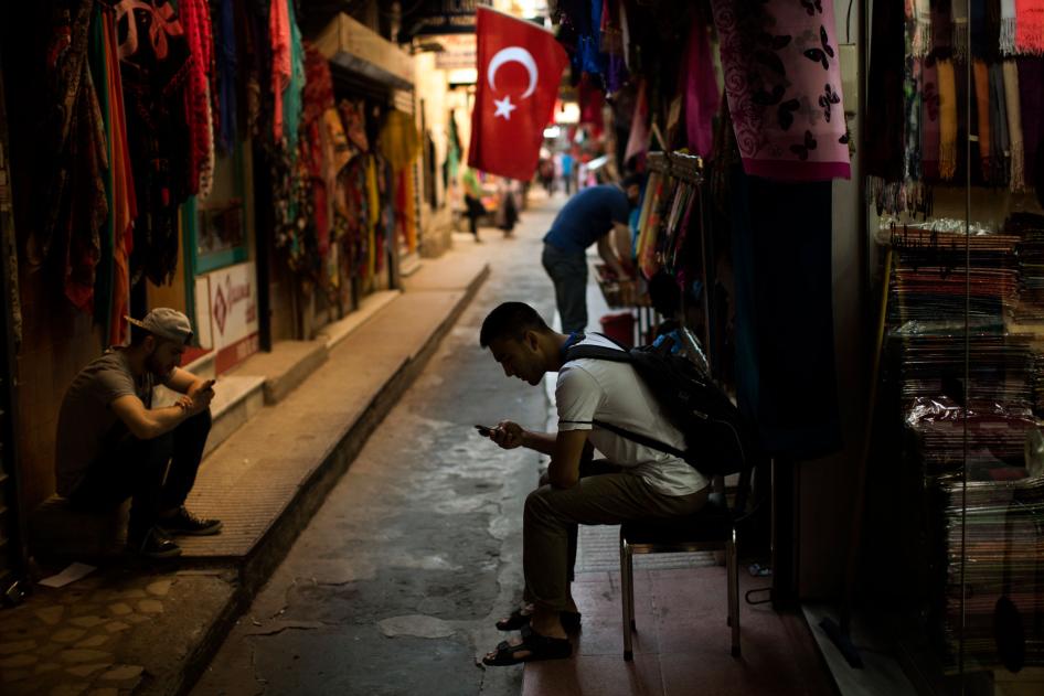 People check their phones at a market in central Istanbul, Türkiye, July 18, 2019.