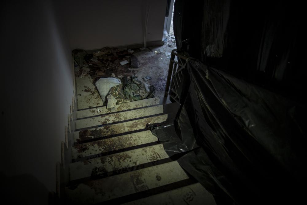 A stairwell with bloody debris and clothing