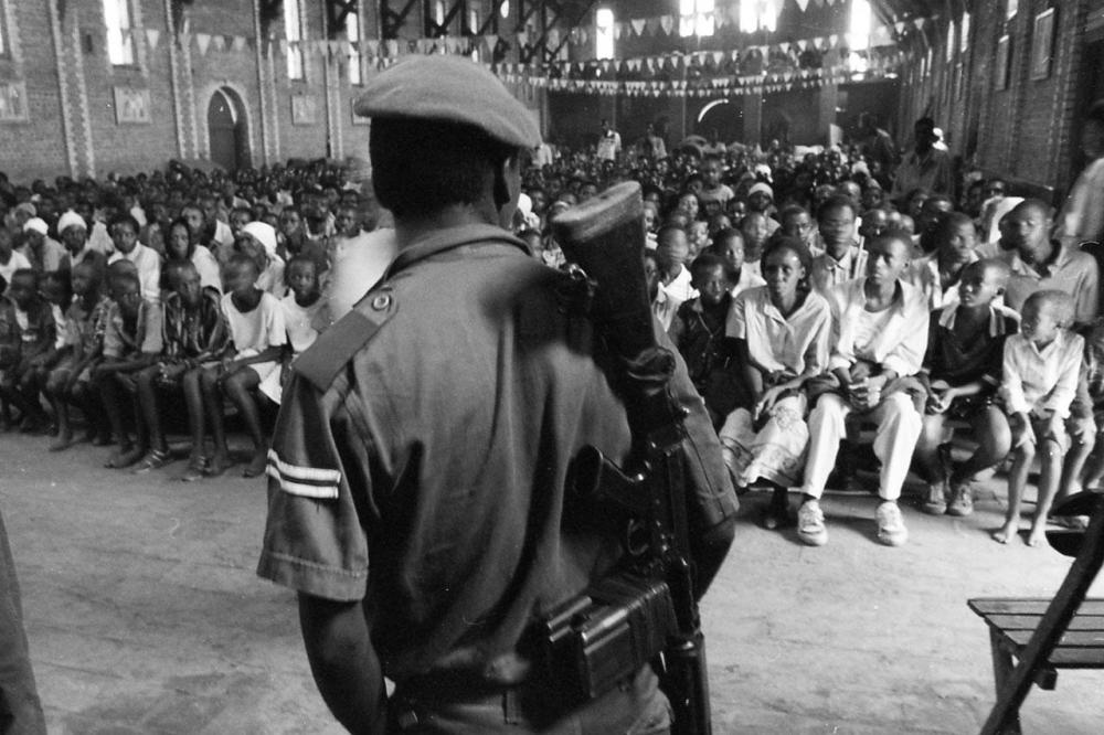 A crowd of mostly Tutsi civilians, seeking protection against Hutu militiamen, sit in the Sainte Famille Catholic church in the then-government controlled part of Kigali, listening to a member of the security services address them. Over several months, ma