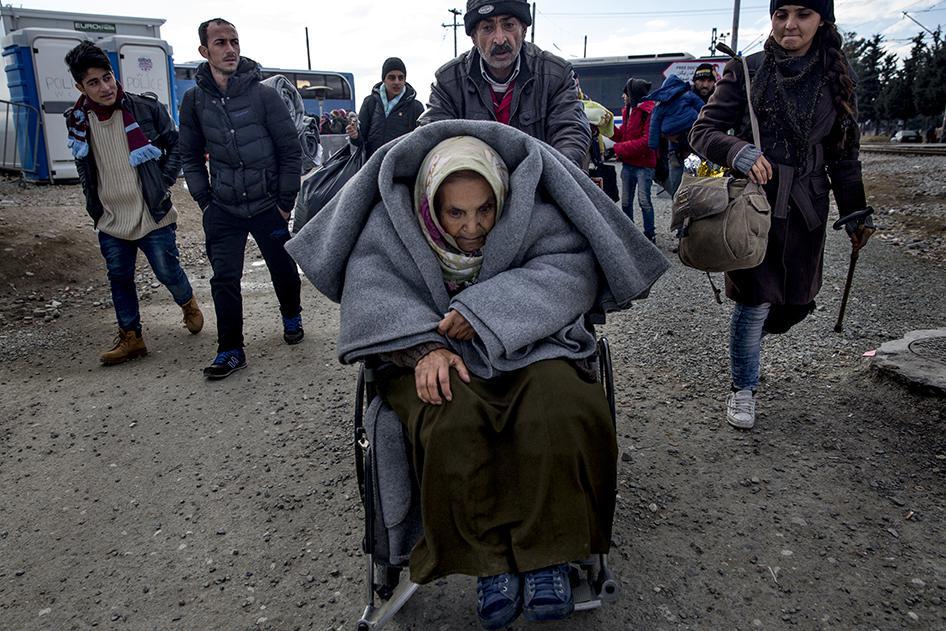 A family with an elderly woman in a wheelchair make their way to the Greek-Macedonia border at Idomeni in freezing winter weather.  January 26, 2016.