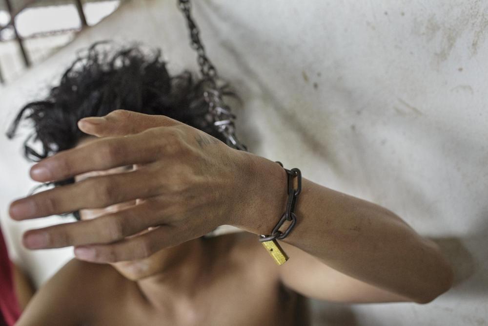 Seorang laki-laki dirantai di pergelangan tangannya di bagian penampungan pria di Pusat Rehabilitasi Galuh, Bekasi. 