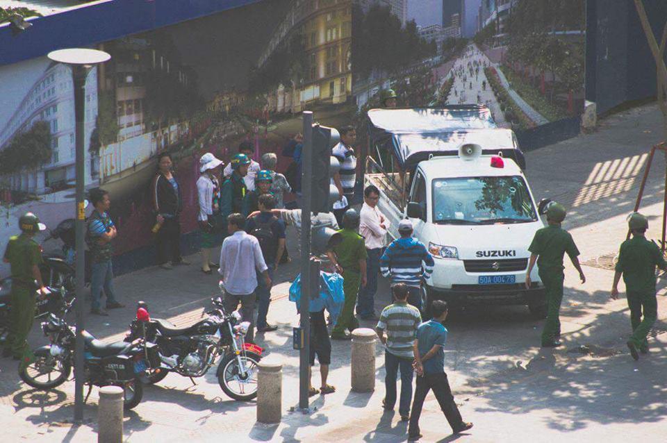 Security forces surround Huynh Ngoc Chenh before taking him into a van to a local police station.