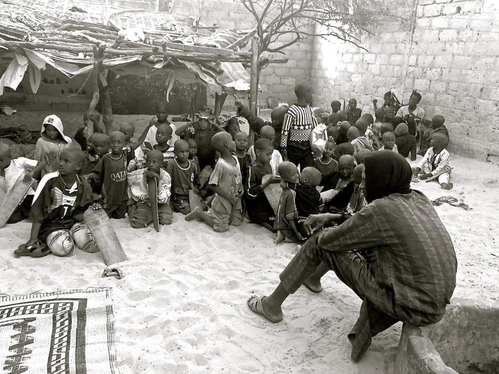 L’assistant d’un maître coranique surveille des talibés dans un daara [école coranique] de Saint-Louis au Sénégal. Une cinquantaine de jeunes talibés, dont certains n’ont que six ans, vivent dans cette école. 