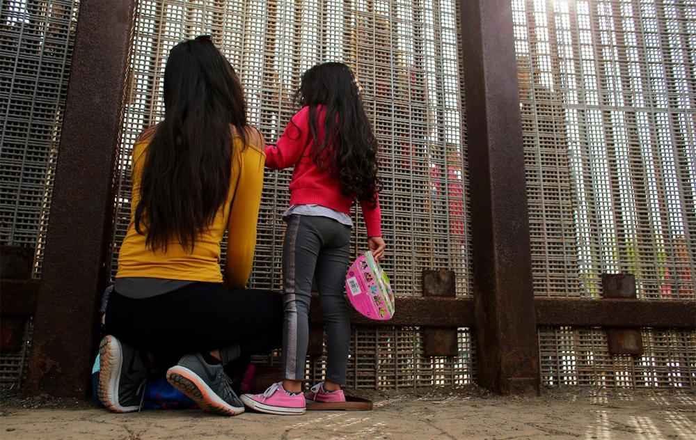 Families chat while separated on either side of the US-Mexico border fence at Border Field State Park, California, November 19, 2016. 