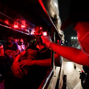A police officer checks the temperatures of passengers inside a jeepney at a checkpoint in Manila, Philippines, March 16, 2020. 
