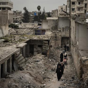 Women walk in a neighborhood heavily damaged by airstrikes in Idlib, Syria, March 12, 2020.