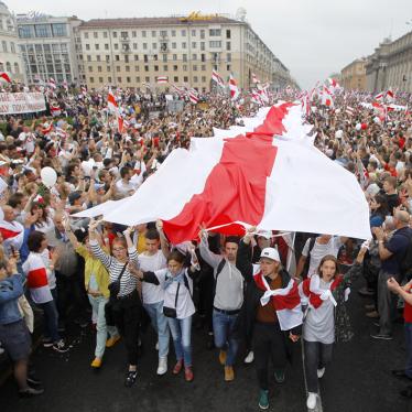 Demonstrators carry a huge historical flag of Belarus as thousands gather for a protest at the Independence square in Minsk, Belarus, Aug. 23, 2020.