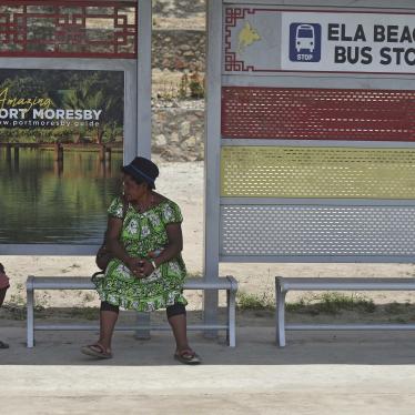 A boy and a woman at a bus stop in Port Moresby.
