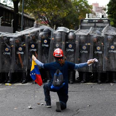 A man kneels in front of police blocking a march called by opposition political leader Juan Guaido in Caracas, Venezuela, Tuesday, March 10, 2020. 