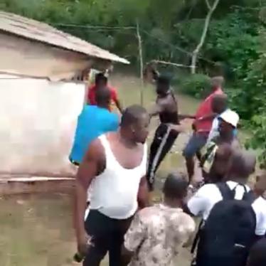 A blurry screenshot from a video showing a mob of men 