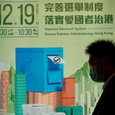A man walks past a poster promoting the upcoming legislative elections in Hong Kong